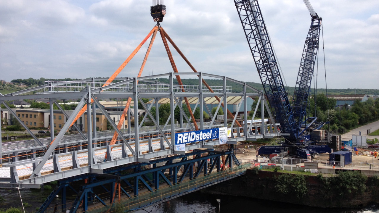 Bridge being made by Reidsteel company with large cranes and steel structures 